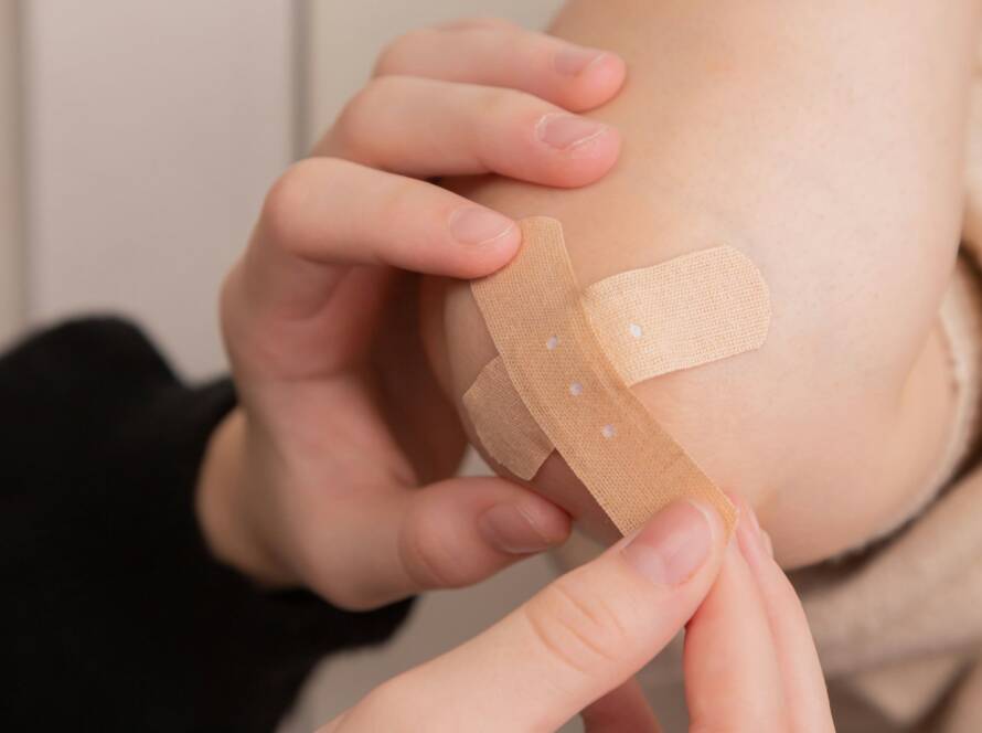 person holding band aid on left hand